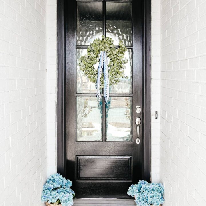 Image for Black Door With Green Wreath & Blue Flowers