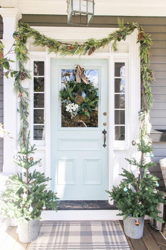 Cozy holiday home entrance decorated with greenery and a festive wreath.