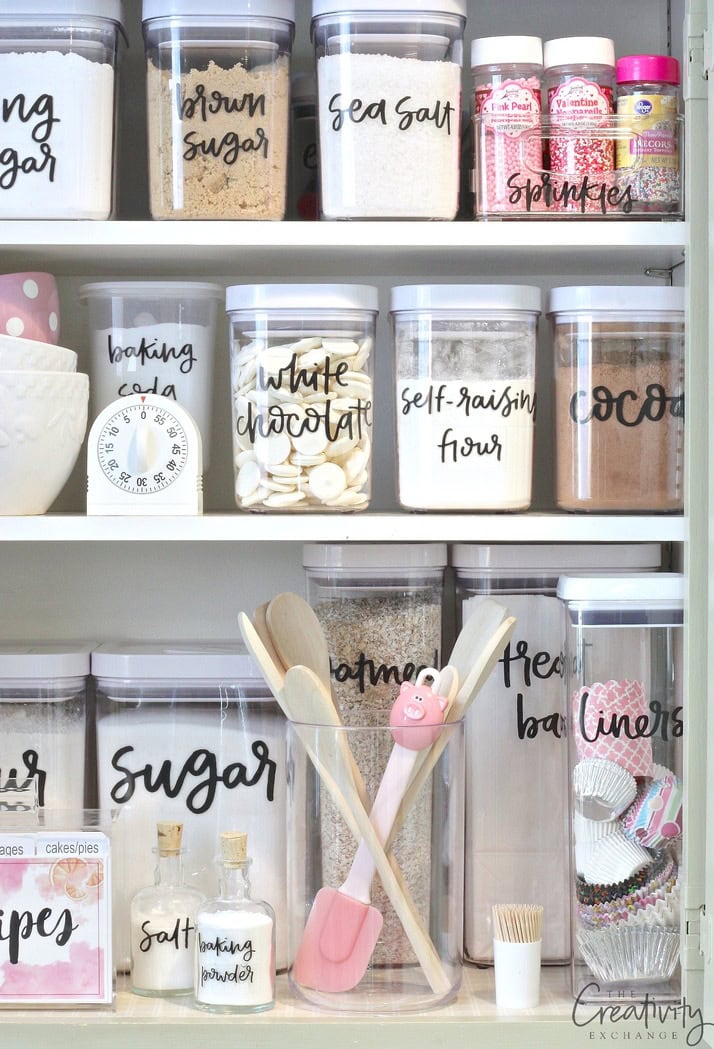 Kitchen shelf with labeled jars of baking ingredients and utensils.