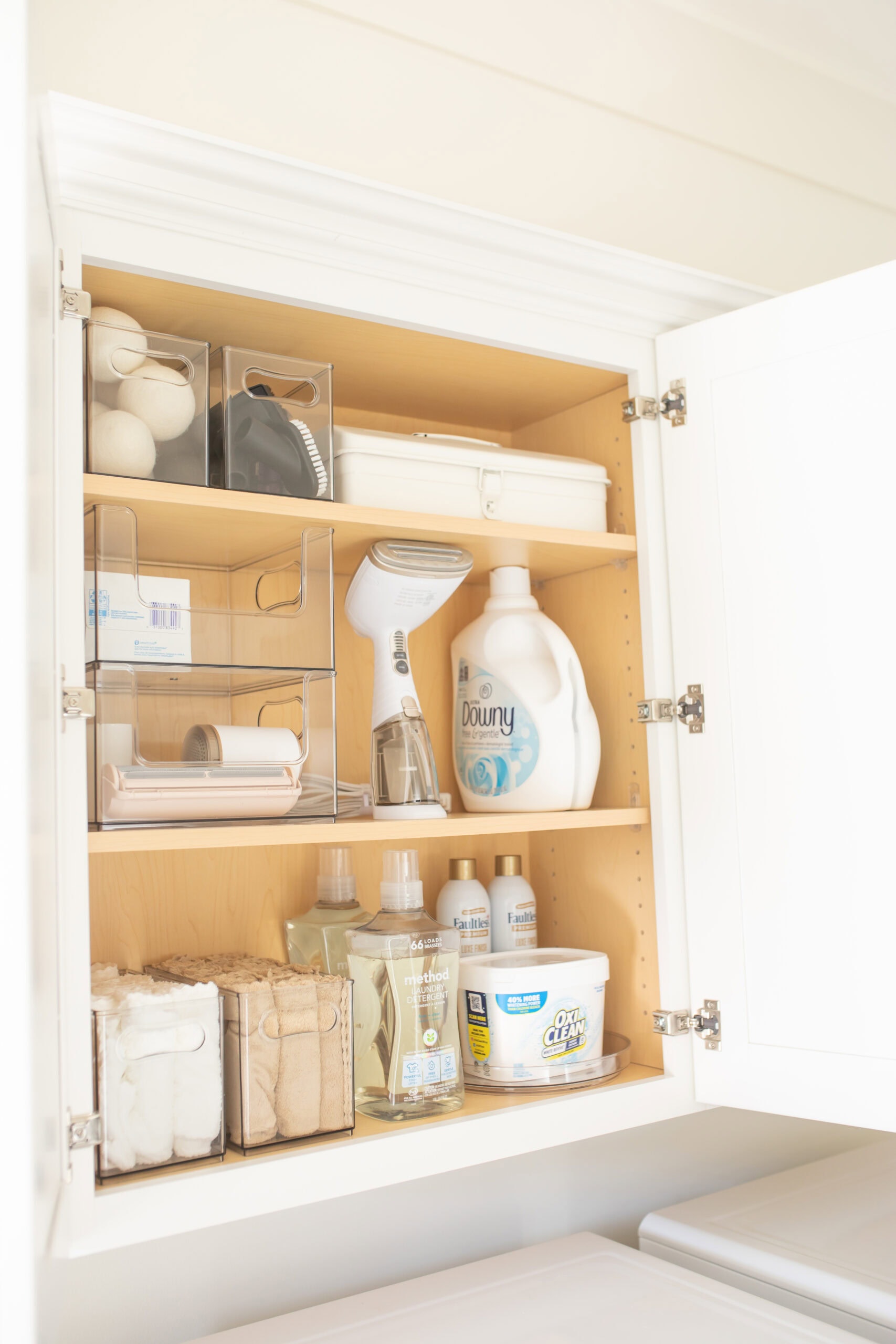Kitchen cabinet with cleaning supplies and storage containers.