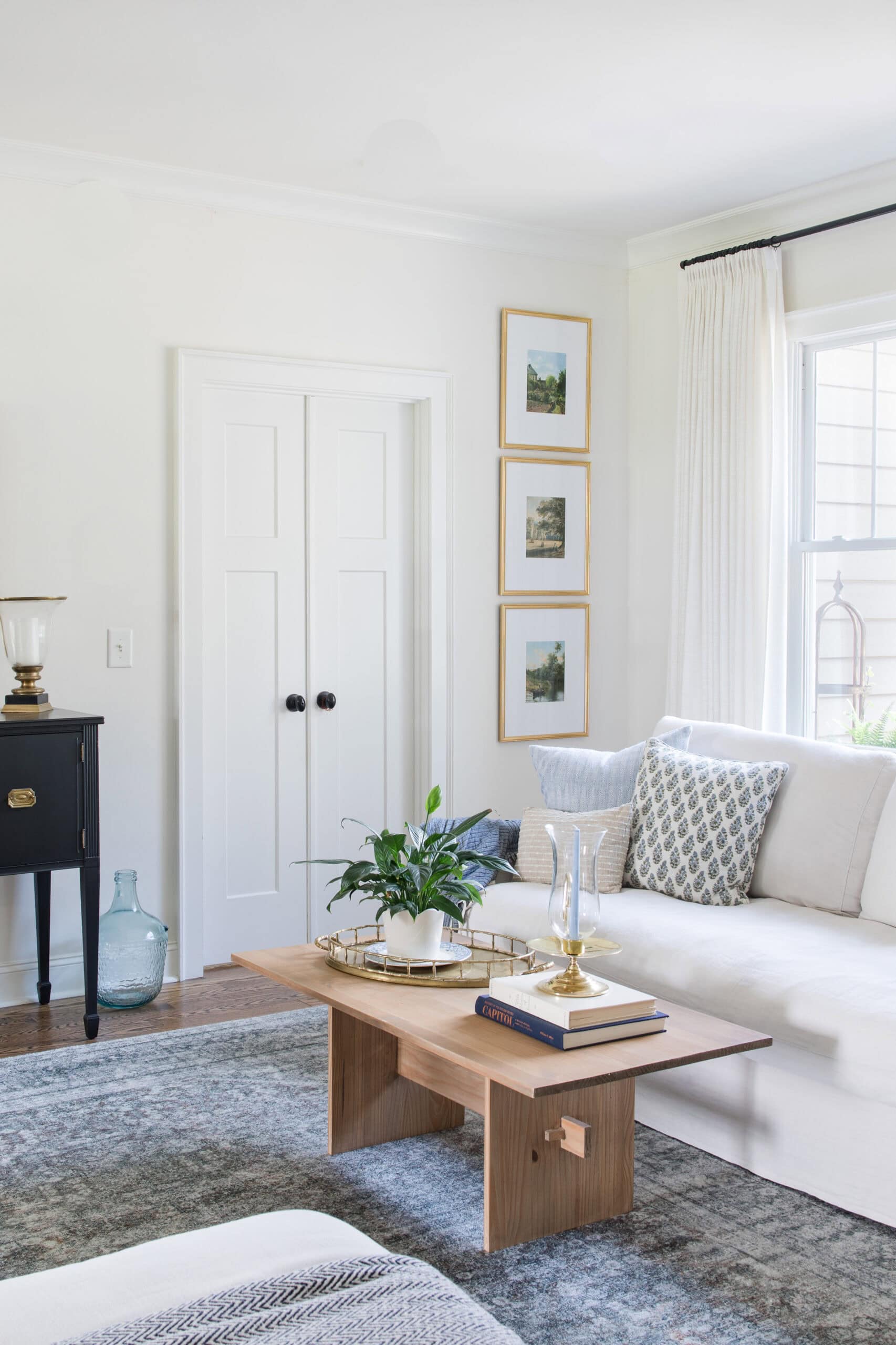 Bright living room with white sofa, wooden coffee table, and natural light.