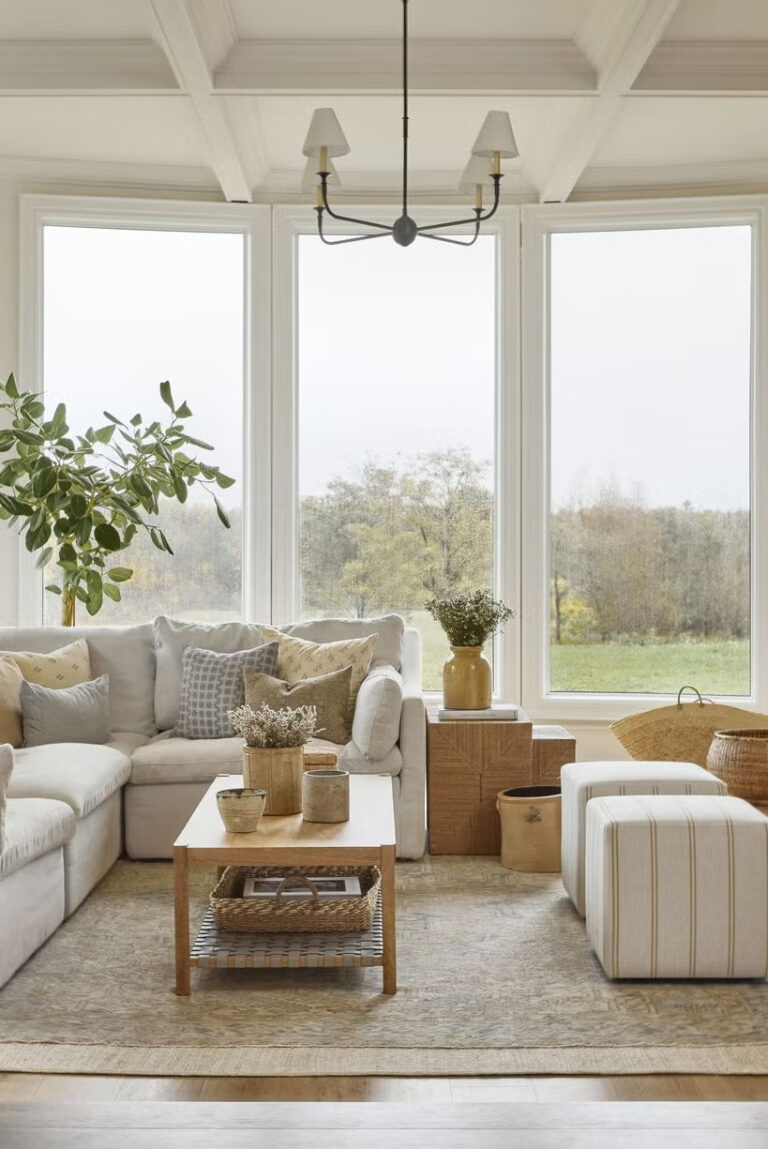 Bright living room with large windows, cozy sofa, and natural decor.